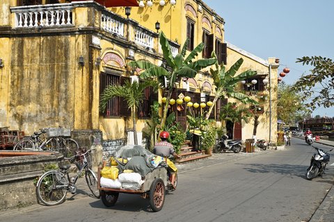 Gebäude aus der Kolonialzeit in Vietnam am geschäftigen Straßenrand.