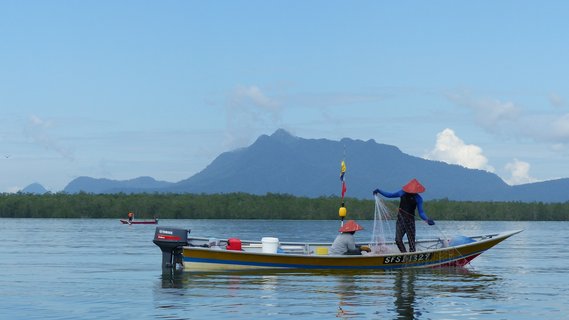 Ein Boot mit Fischern bei der täglichen Arbeit in Malaysia.