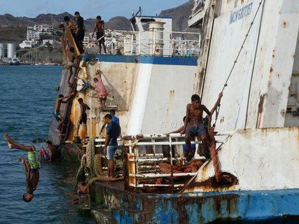 Kinder auf einem rostigen Boot am Ufer der Kapverden