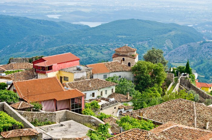 Blick über die Dächer des Dorfes Kruja auf die hügelige Landschaft 