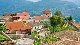 Blick über die Dächer des Dorfes Kruja auf die hügelige Landschaft 