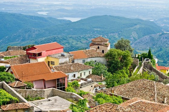 Blick über die Dächer des Dorfes Kruja auf die hügelige Landschaft 