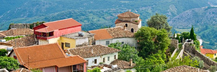 Blick über die Dächer des Dorfes Kruja auf die hügelige Landschaft 