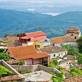 Blick über die Dächer des Dorfes Kruja auf die hügelige Landschaft 
