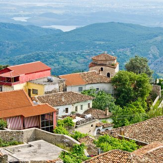 Blick über die Dächer des Dorfes Kruja auf die hügelige Landschaft 