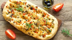 Ein italienisches Focaccia mit Tomaten, Oliven und Rosmarin