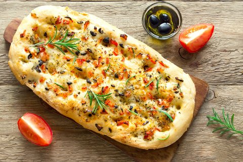 Ein italienisches Focaccia mit Tomaten, Oliven und Rosmarin