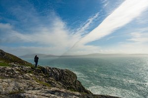 Eine Frau blickt auf das Meer in der Region von Sheeps Head