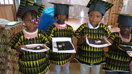 Vier Teilnehmer des Vorschulprojekts PEPE auf São Tomé zeigen ihre Schulmaterialien.