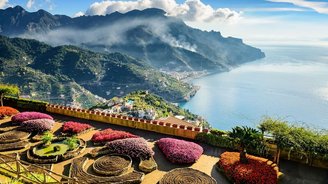 Über bunte Blumenrabatten schaut man die Steilküste hinunter auf das Meer vor Ravello.