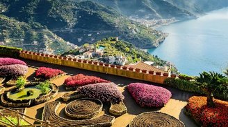 Über bunte Blumenrabatten schaut man die Steilküste hinunter auf das Meer vor Ravello.