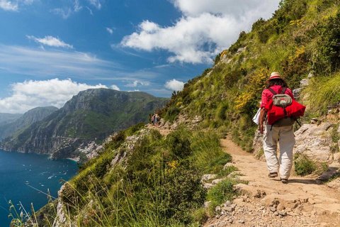 Ein Wanderer läuft auf einem schmalen Weg an der Küste