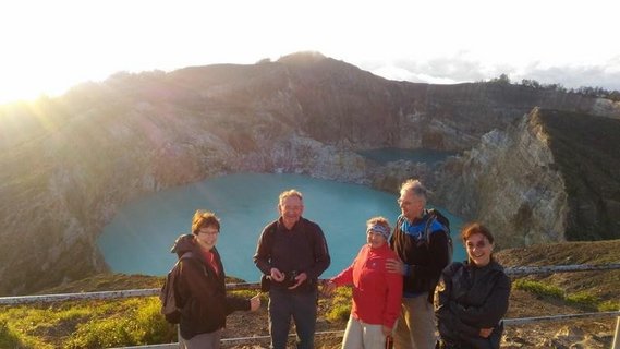 Die Reisegruppe mit Bergen und einem See im Hintergrund