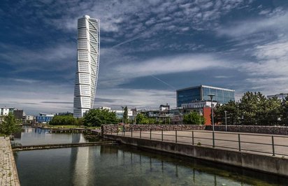Der Turning Torso des Architekten Calatrava in Malmö Am vorderen Bildrand entlang zieht sich ein Kanal, dahinter erhebt sich das gedrehte Hochhaus Turning Torso in Malmö.