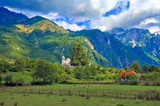 Blick auf ein einsames Dorf vor der Berglandschaft der Albanischen Alpen