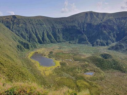 Einblick in einen grün bewachsenen Vulkankrater