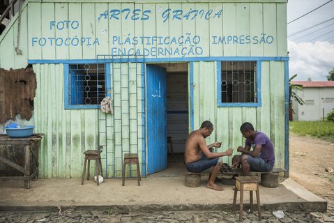 Zwei spielende Männer vor einem kleinen Laden auf São Tomé 