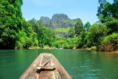 Boot zur Kong Lor Höhe in Laos Spitze eines Bootes zeigt Richtung eines Berges