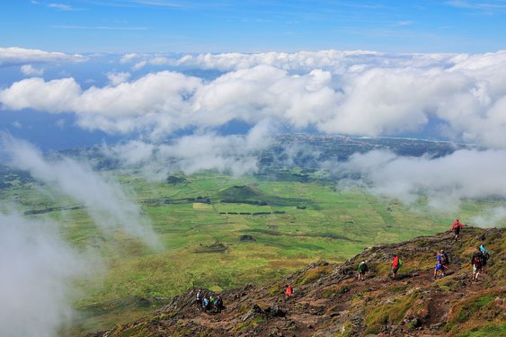 Reisegruppe wandert bergabwärts, neben den Wolken, den Vulkan Pico herunter