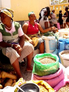 Einheimische Frauen sitzen vor ihrem Verkaufsstand auf einem Markt