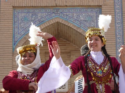 Zwei Frauen tanzen in traditionellen usbekischen Roben