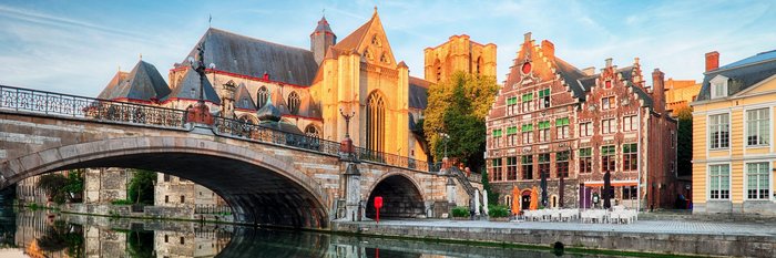 Ausblick auf die Häuserfront von historischen Häusern und Kirchen am Genter Kanal