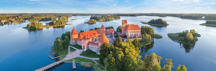 Die Inselburg Trakai in Litauen, malerisch auf einer kleinen Insel im Galvėsee gelegen, umgeben von Wasser und grüner Natur.