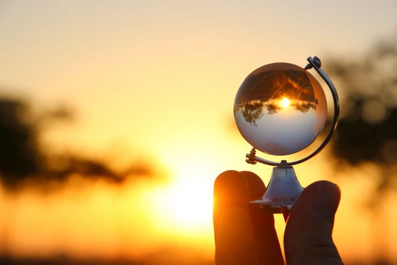 Ökologisches Reisen Ein Globus aus Glas bricht den Sonnenuntergang
