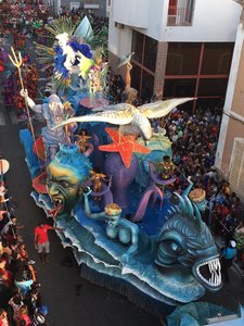 Blauer Karnevalswagen auf der Straße mit Zuschauern