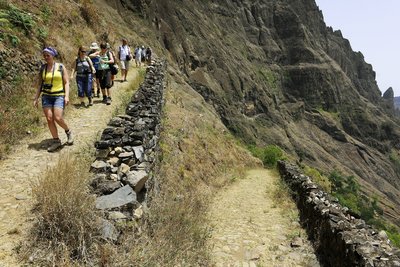 Eine Wandergruppe schreitet auf befestigten Wegen einen steilen Hang auf den Kapverden hinab.