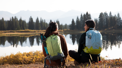 Wanderer sitzen am See und schauen in die Landschaft