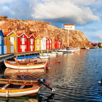 Die Boote in Reih und Glied vor vielen bunten Häusern am Steg