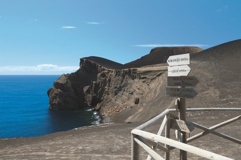 Wanderweg mit Wegweiser in Vulkanlandschaft.