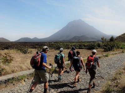 Eine Gruppe von Reisenden wandert auf der Insel Fogo auf den Kapverden, im Hintergrund zu sehen ist der Vulkan Pico..