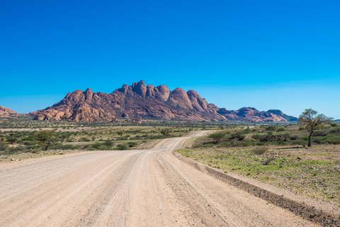 Eine unbefestigte Straße führt zum Inselberg in der Ferne