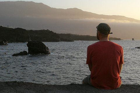 Ein Mann blickt in den Sonnenuntergang auf El Hierro