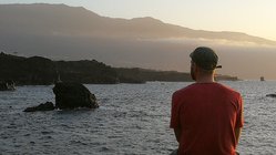 Ein Mann blickt in den Sonnenuntergang auf El Hierro