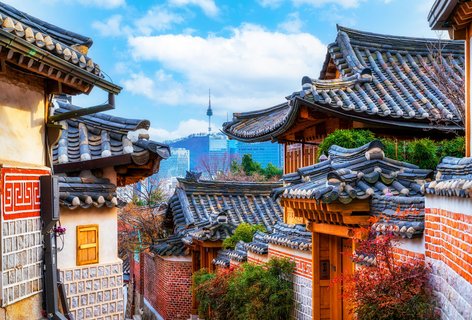 Auf dem Bild befindet man sich in dem traditionellen Hanokdorf Bukchon in Seoul mit Blick auf den Berg Namsan.