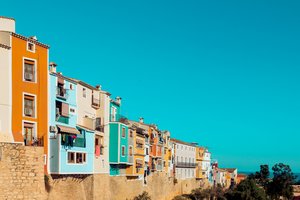 Alte, bunte Häuser im Aitana Gebirge mit strahlend blauem Himmel im Hintergrund