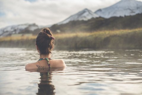 Eine Frau genießt eine heiße Quelle in Island