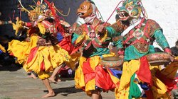 Maskentänzer in Bhutan Männer tanzen einen Maskentanz in bunten Kostümen