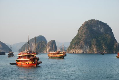 Halongbucht in Vietnam Traditionelle Holzboote fahren in der Halongbucht in Vietnam.