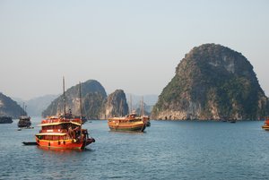 Traditionelle Holzboote fahren in der Halongbucht in Vietnam.