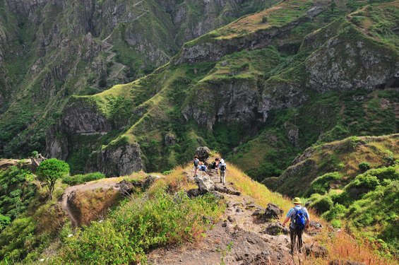 Wanderer auf einem steilen Wanderweg in grüner Landschaft auf Santo Antao.