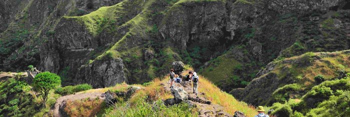 Santo Antao: Wanderparadies der Kapverden Wanderer auf einem steilen Wanderweg in grüner Landschaft auf Santo Antao.