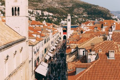 Eine große Menschenmenge läuft durch eine Altstadt