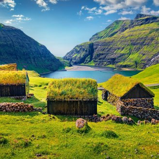 Grassodenhäuser in schöner, grüner Landschaft auf den Färöer-Inseln