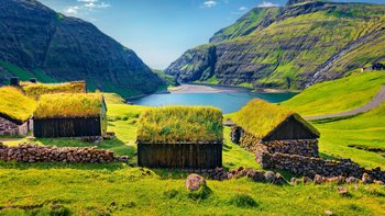 Grassodenhäuser in schöner, grüner Landschaft auf den Färöer-Inseln
