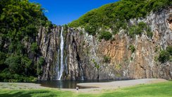 Ein schmaler Wasserfall stürzt von einer hohen Bergwand hinunter 