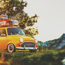Vollbeladener Fiat fährt auf Landstraße in Richtung Berge